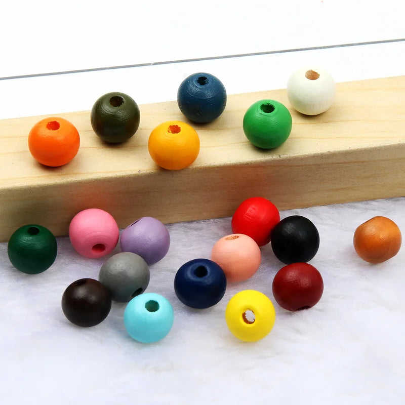 A collection of colorful natural wooden beads arranged on a light wooden board.