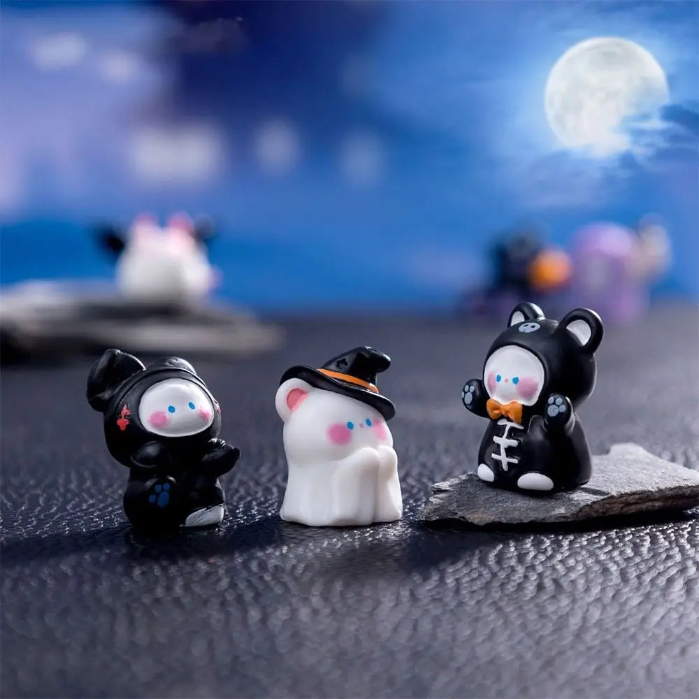 A collection of charming cartoon pumpkin bear figurines in black and white are displayed on a dark surface against a blue nig