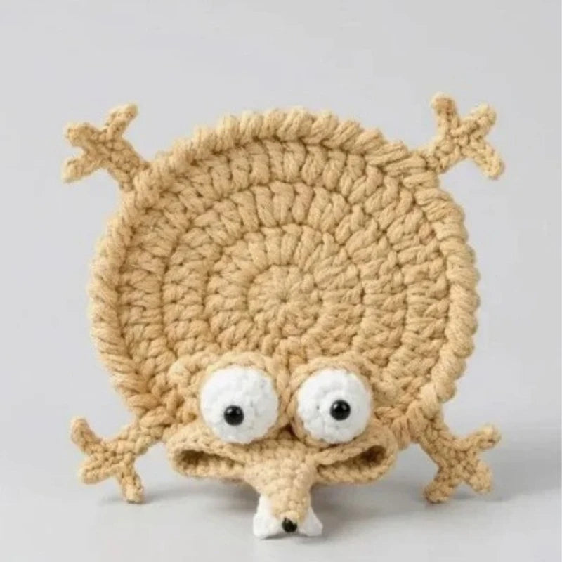 Handmade crochet lizard coaster featuring a funny animal design in a beige color.