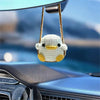 Handmade crochet chicken charm hanging from a mirror on a car dashboard