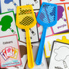 A set of four colorful plastic fly swatters in yellow, blue, purple, and yellow are displayed on cards.
