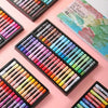 A collection of soft oil pastels in various colors arranged in wooden and black palettes for artists.