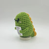 Handwoven positive energy pencil ornament made of green crochet yarn with small black glasses and yellow accents.