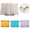 A set of adjustable portable book stands in yellow, blue, and purple colors shown alongside an open book.