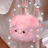 A pink fluffy plush pig keychain charm attached to a white fabric bag.