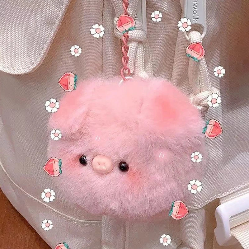 A pink fluffy plush pig keychain charm attached to a white fabric bag.