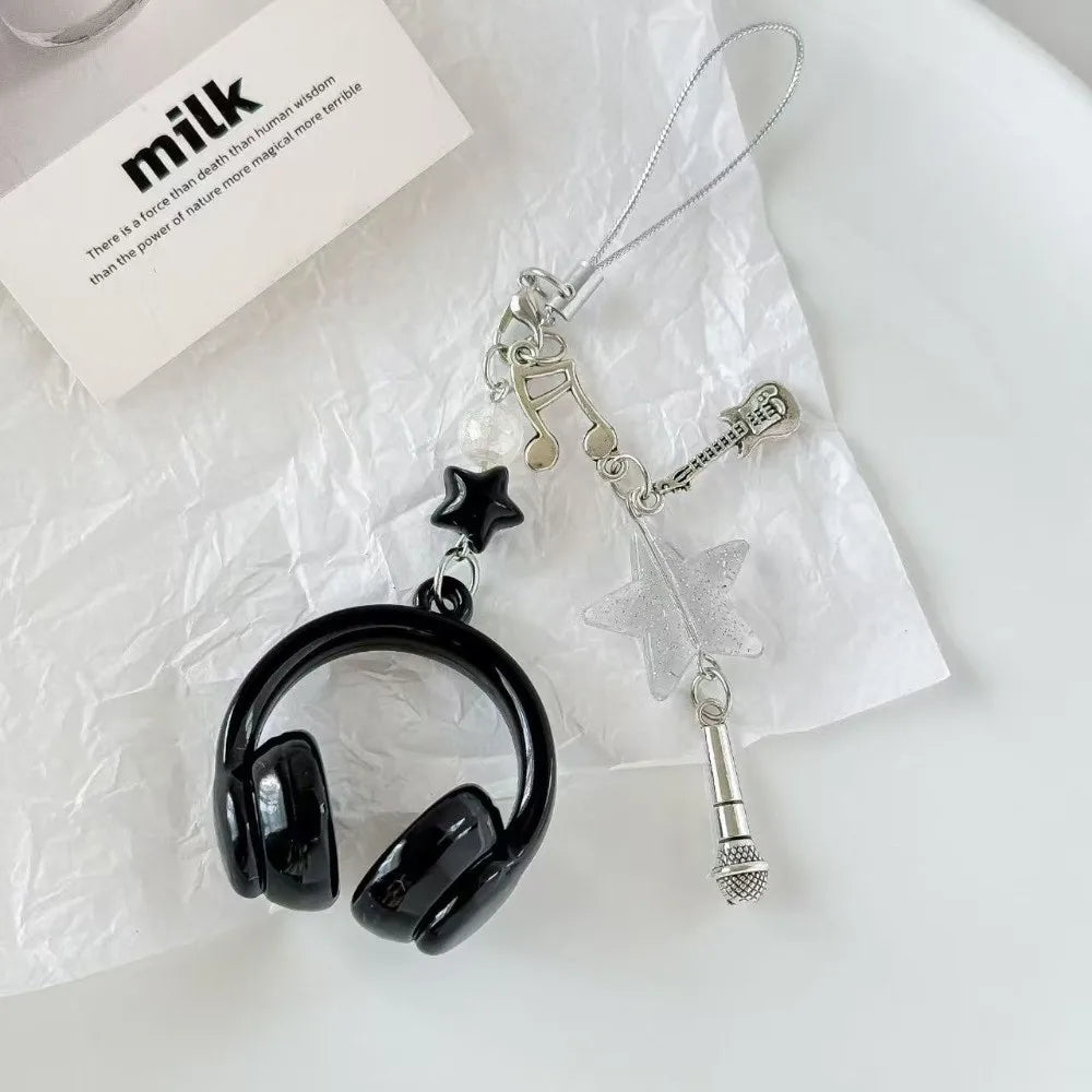 A silver beaded wing cross phone lanyard keychain is displayed on crumpled white paper.