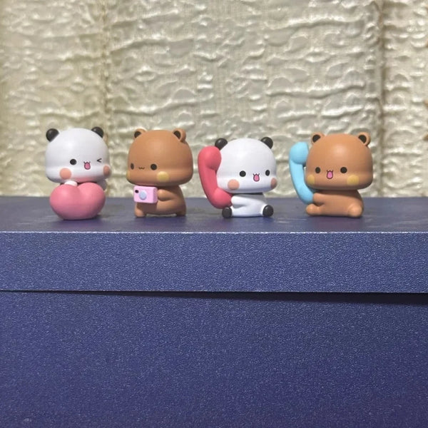 A set of four blind box panda couple collectible figures in various colors and poses.