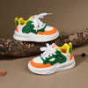 A pair of yellow and green casual sneakers with white laces and thick white soles resting on a brown log.