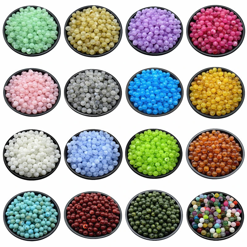 A collection of various colored acrylic round beads for jewelry making, including green, yellow, purple, pink, blue, and oran