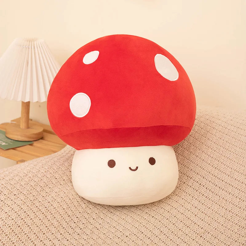 A plush pillow shaped like a red and white spotted mushroom with a smiling face.