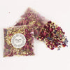 A pile of natural dried rose petal confetti scattered on a white surface.
