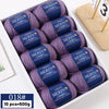 A box of 10 skeins of YEDAN MERIN worsted wool yarn in purple and blue shades for knitting projects