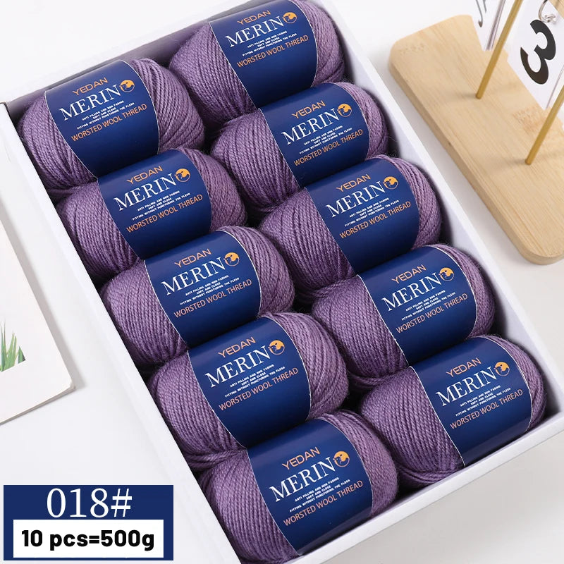 A box of 10 skeins of YEDAN MERIN worsted wool yarn in purple and blue shades for knitting projects
