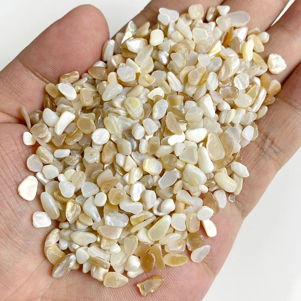 A handful of natural tumbled stone chips in various shades of beige and white stones for jewelry making