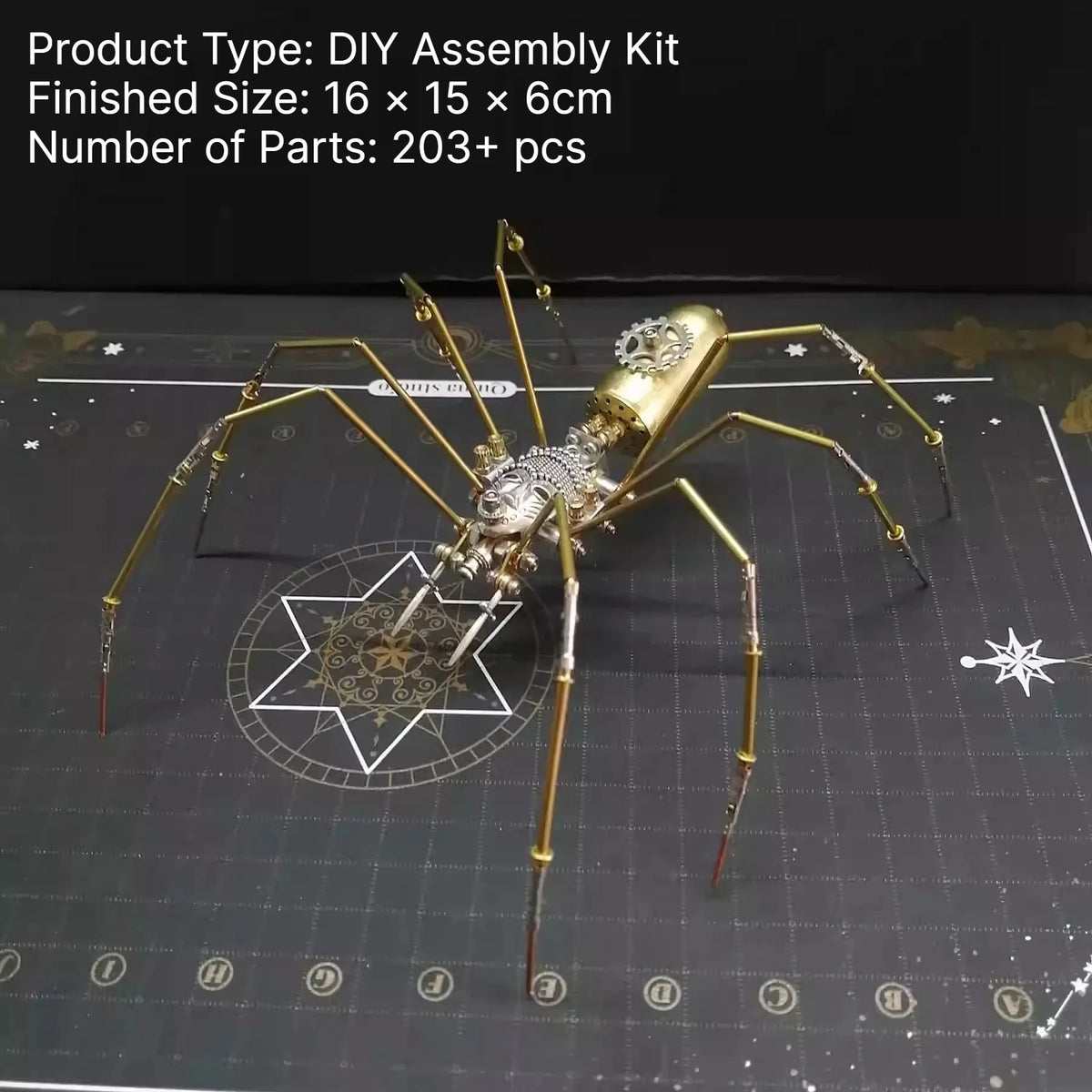 A detailed steampunk metal spider assembly kit with gold-colored legs and body resting on a dark grid background.