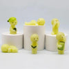 A collection of yellow glow-in-the-dark elf figures displayed on white circular stands.