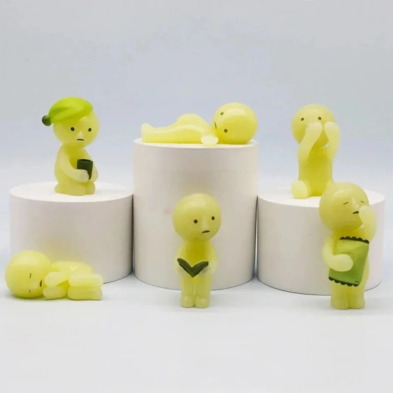 A collection of yellow glow-in-the-dark elf figures displayed on white circular stands.