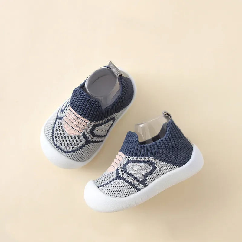 A pair of breathable anti-slip baby first walker shoes in gray and pink patterned knit fabric.