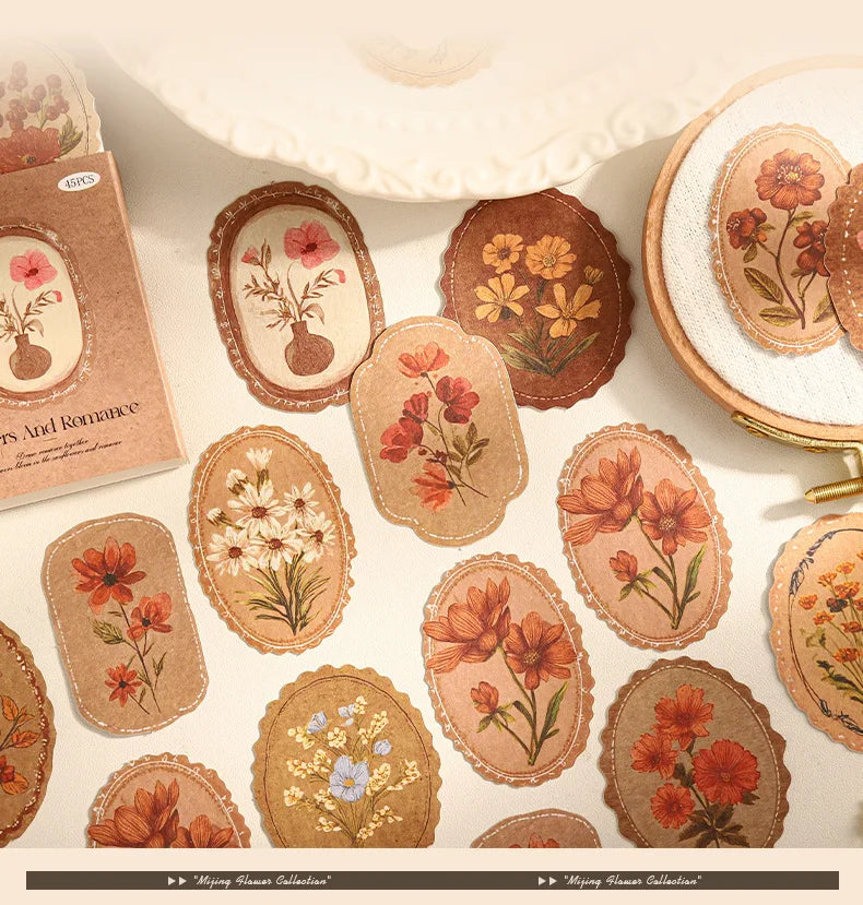 A collection of vintage floral stickers in various shades of orange, red, and green on kraft paper.