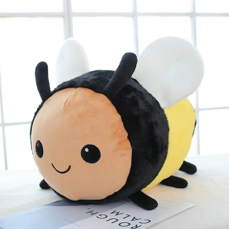 A cute plush toy of a bee with black and yellow body and white wings sitting on a white surface.