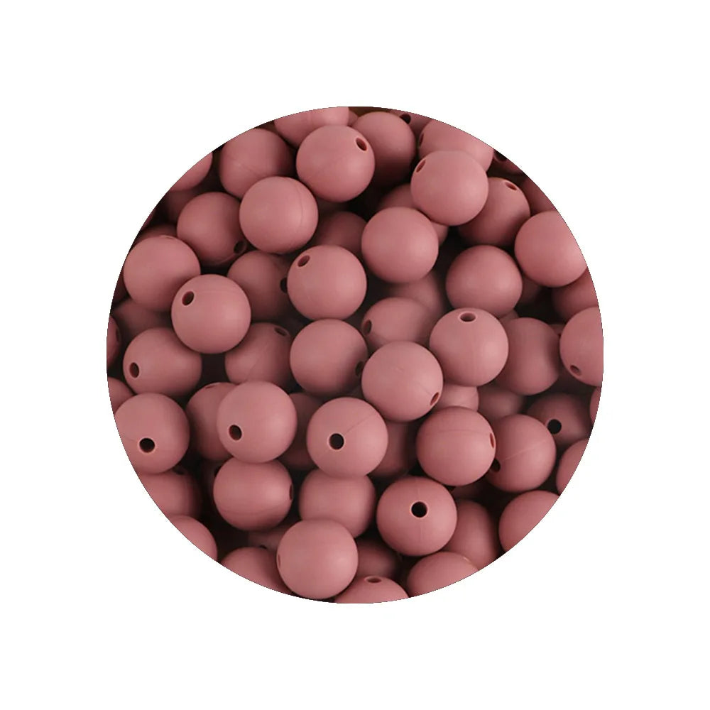 A circular arrangement of pink silicone beads in various sizes for DIY jewelry making