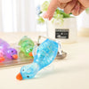 A hand is squeezing a bright blue glittery duck toy, which is attached to a clear plastic holder.
