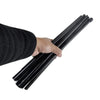 A hand is holding a black adjustable foldable metal easel stand with multiple rods.