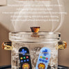 A clear glass container holds a lion-shaped silicone baby teether with a remote control design, surrounded by ice.
