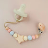 A wooden pacifier clip with a silicone bead chain and a light wood star shape.