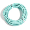 A coil of light mint green round braided leather cord for jewelry making and DIY crafts.