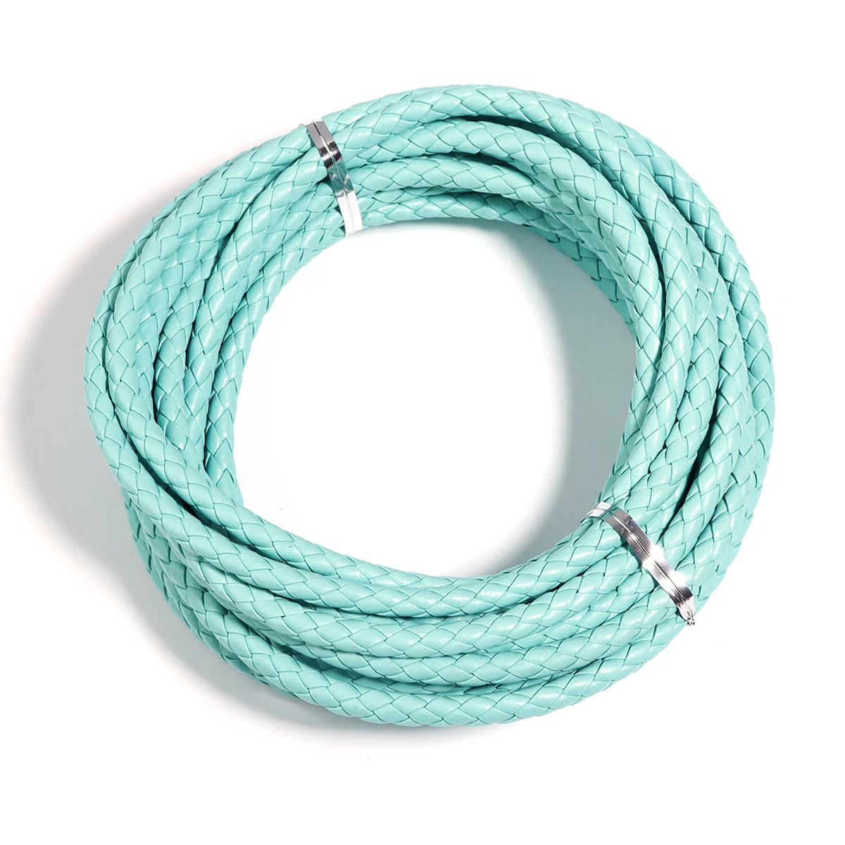 A coil of light mint green round braided leather cord for jewelry making and DIY crafts.