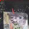 A clear plastic package containing three small animal figures, including a red stick, for sale.