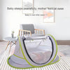 A gray instant pop-up baby tent with a green trim is shown on a floor, suggesting a peaceful sleeping environment.