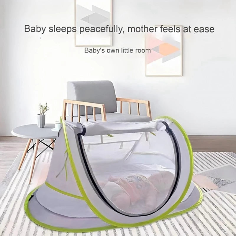 A gray instant pop-up baby tent with a green trim is shown on a floor, suggesting a peaceful sleeping environment.