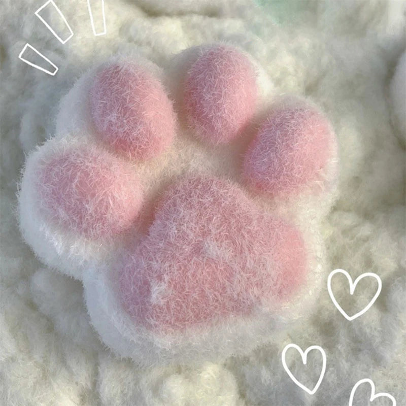 A pink and white fluffy cat paw squishy stress relief toy