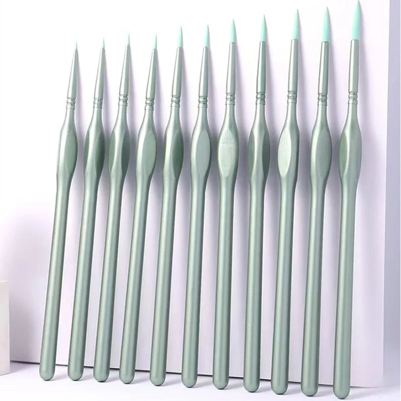 A set of eleven miniature detail paint brushes with natural wood handles arranged in a row.