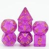A set of seven glitter translucent polyhedral dice in various shapes and colors.
