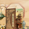 A DIY book nook kit featuring a detailed miniature scene with traditional architecture and LED lighting.