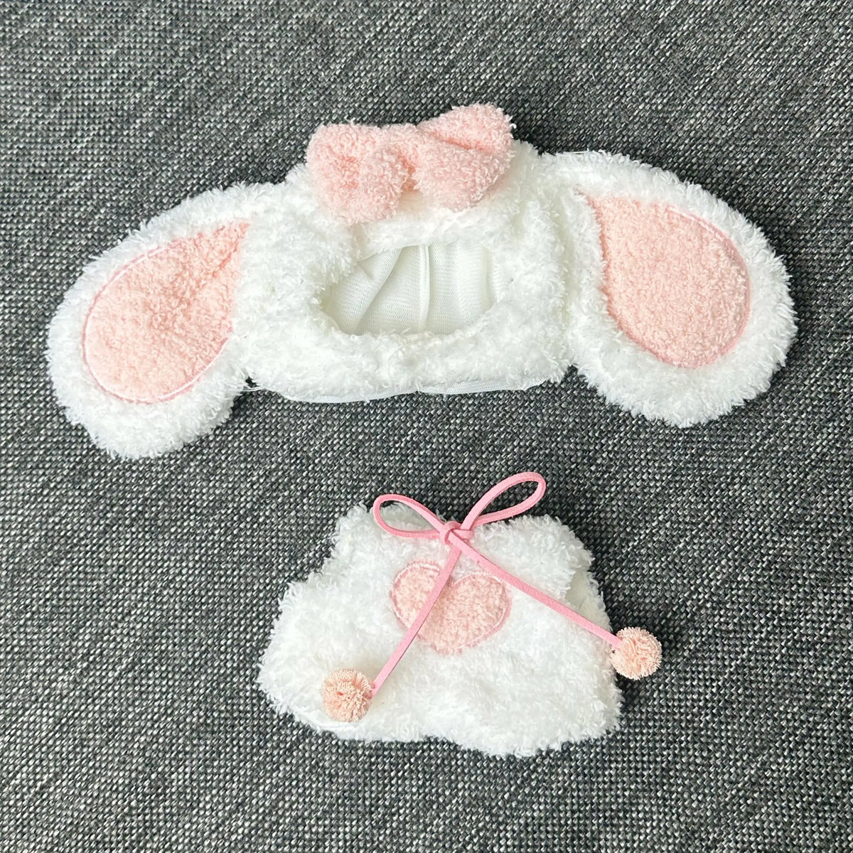 White rabbit costume with pink ears and a heart-shaped bow for a doll