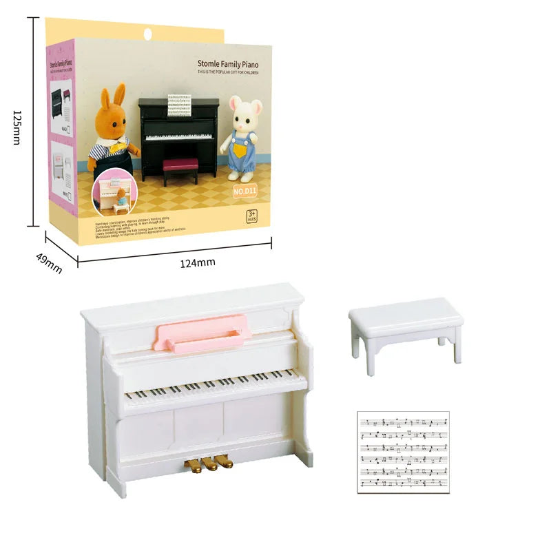 A wooden miniature piano set with a black keyboard and pink bench, shown next to a box featuring animal figures.