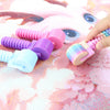 A hand holds a colorful, detachable diamond painting roller with various colored cylinders on a pink background.