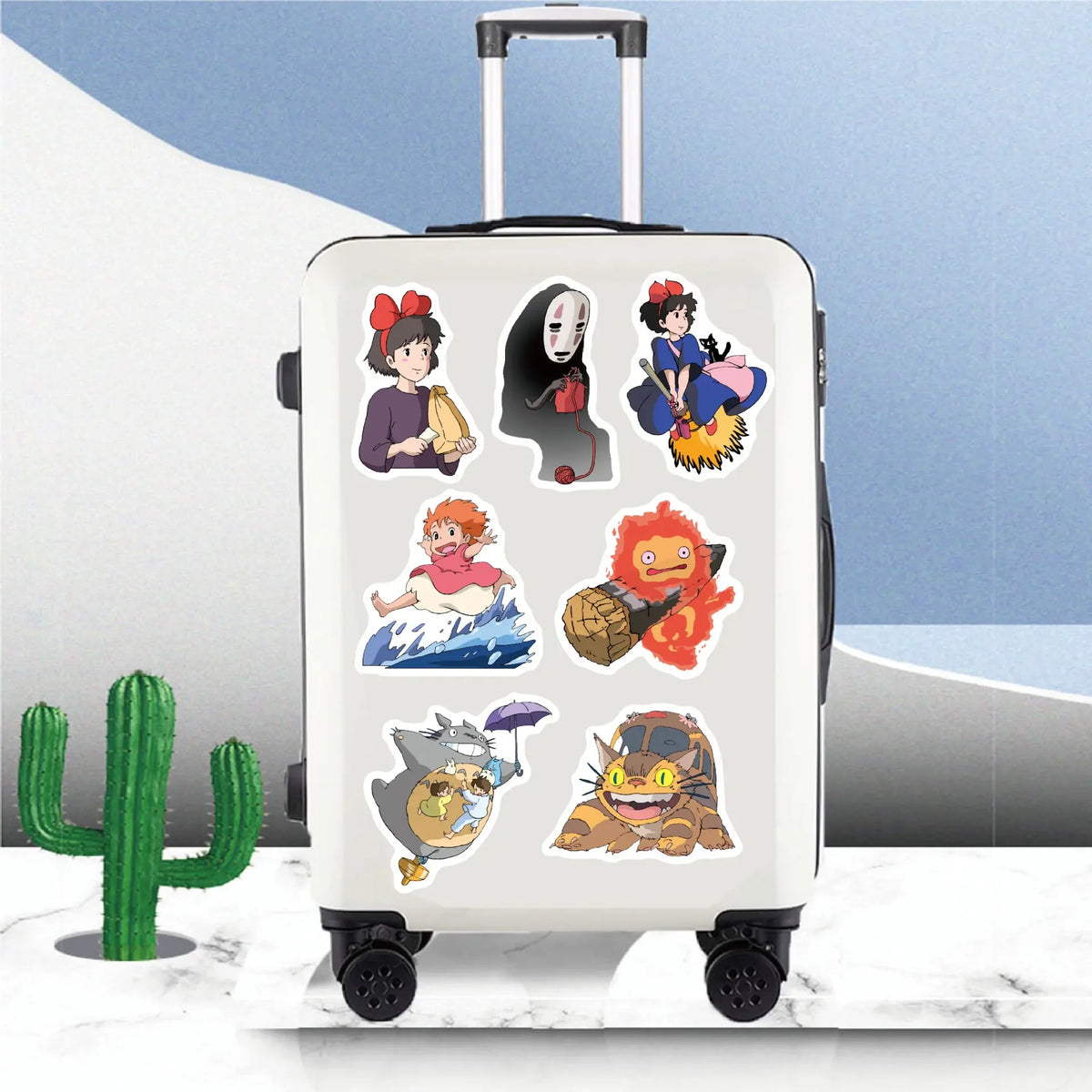 A white rolling suitcase features various anime character stickers on its surface.
