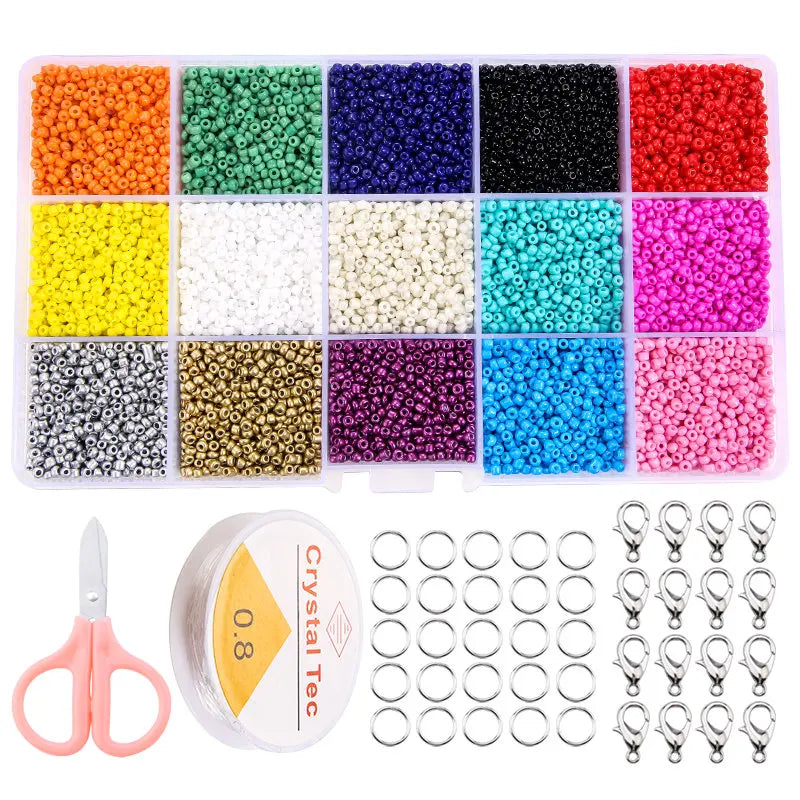 A variety of colored glass seed beads in various shades and sizes are displayed in compartments with a pair of pliers and sto