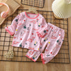 Pink long sleeve cotton pajama set for children featuring a repeating dinosaur pattern