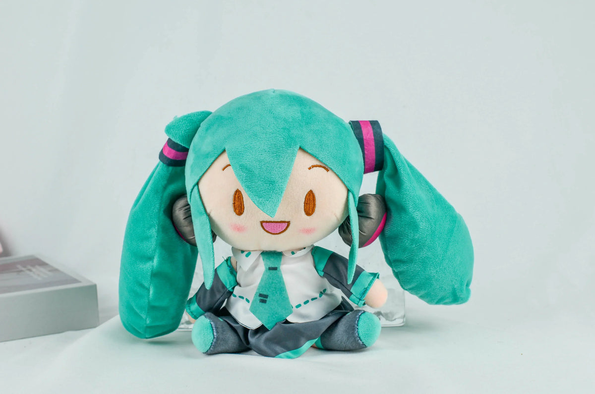 A cute teal Hatsune Miku plush doll with long hair and headphones sitting on a white surface.