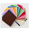 A fan of colorful non-woven felt fabric sheets in various shades of green, yellow, pink, and brown.