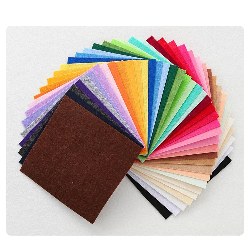 A fan of colorful non-woven felt fabric sheets in various shades of green, yellow, pink, and brown.