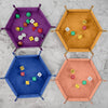 Four hexagonal folding dice trays in purple, orange, blue, and peach colors, each containing various colored dice.