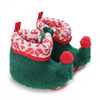 A pair of green fuzzy animal-themed baby first walker shoes with red accents and pom-poms.